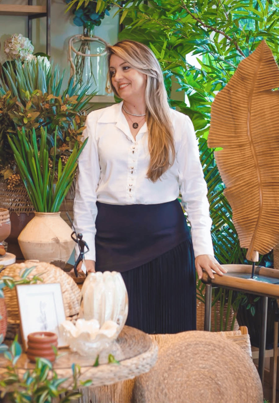 Maria Manfrim em seu ateliê de decoração, cercada de plantas e objetos de decoração